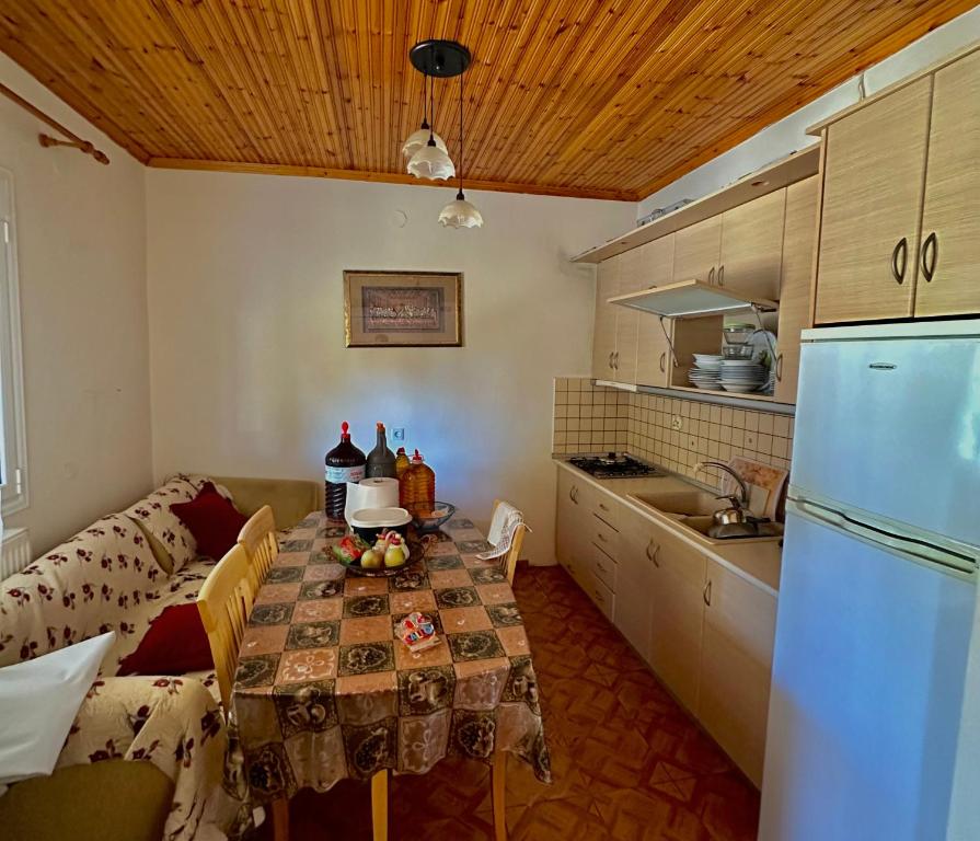 cocina con mesa, sofá y nevera en Chalkidiki rent house, en Vergia