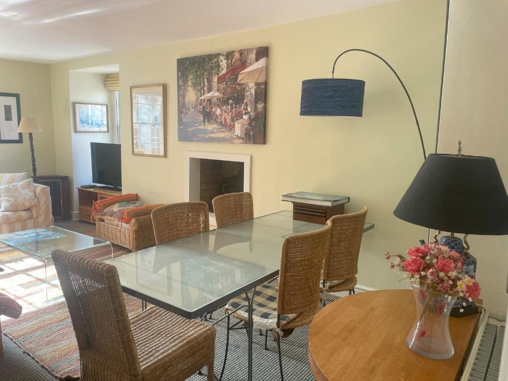 a dining room with a glass table and chairs at Central Georgian Garden Flat with Free Parking in Bath