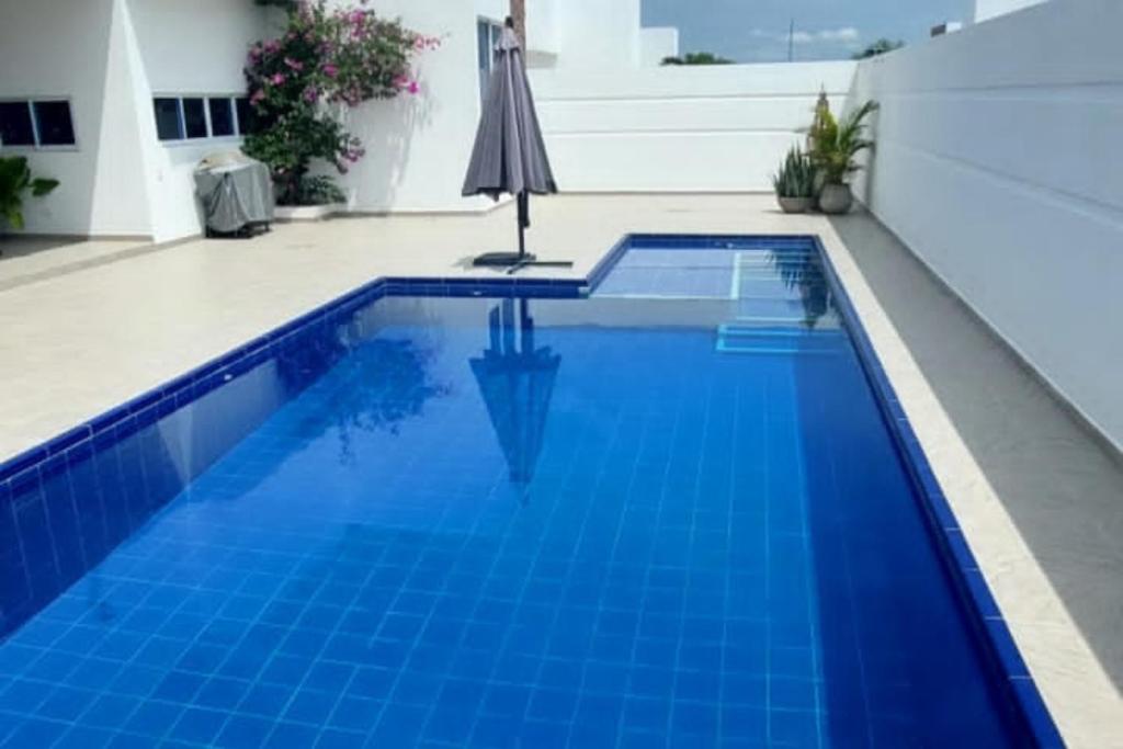 ヒラルドットにあるCasa Quinta Moderna Piscina Privada En via Girardotの青いスイミングプール(傘付)