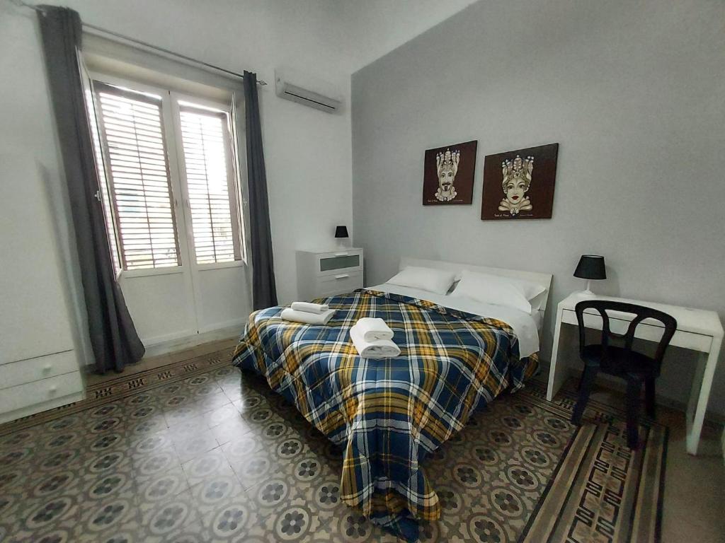 a bedroom with a bed and a table and a window at La Casa del Moro - All' Operà in Palermo