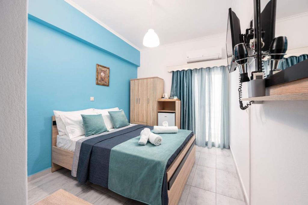 1 dormitorio con 1 cama con pared azul en Lefteris Apartment en Kardámaina