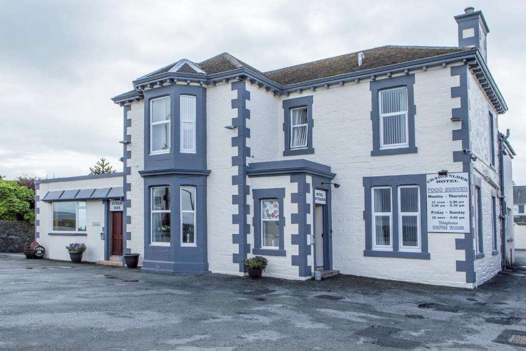 una casa blanca y azul con aparcamiento en Craignelder Hotel, en Stranraer