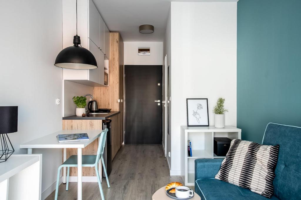 Apartamento pequeño con sofá azul y mesa. en ADLER Room Suite -- prywatna łazienka, dostęp na kod -- BEZPŁATNY PARKING en Lodz