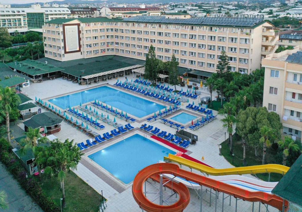 una vista aérea de una piscina con sillas y un tobogán de agua en Xeno Eftalia Resort Hotel en Alanya