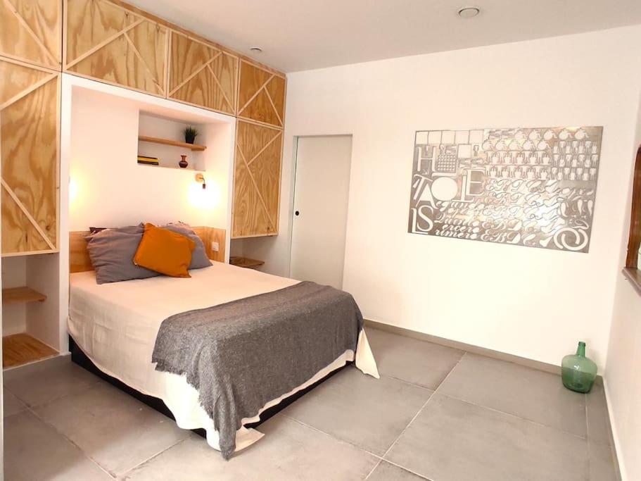 1 dormitorio con 1 cama y una pintura en la pared en Acogedor Loft cerca a estación tren_ calamocha_B en Valencia