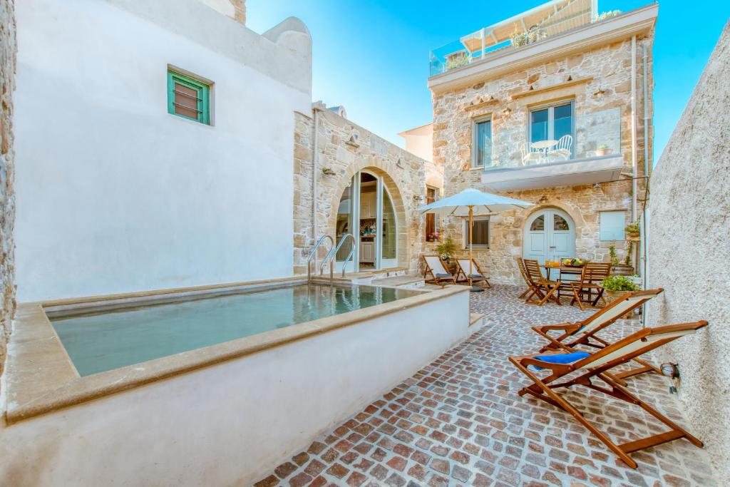 a house with a swimming pool and a patio at Villa Nicola in Kissamos