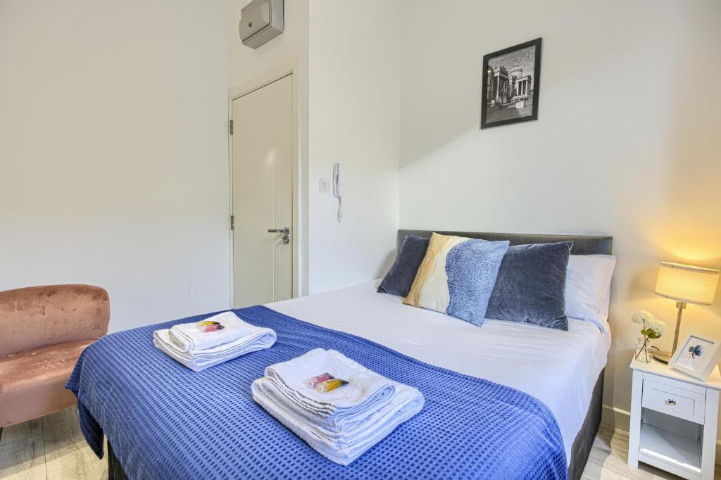 a bedroom with a bed with towels on it at The Finsbury Deluxe Apartments in London