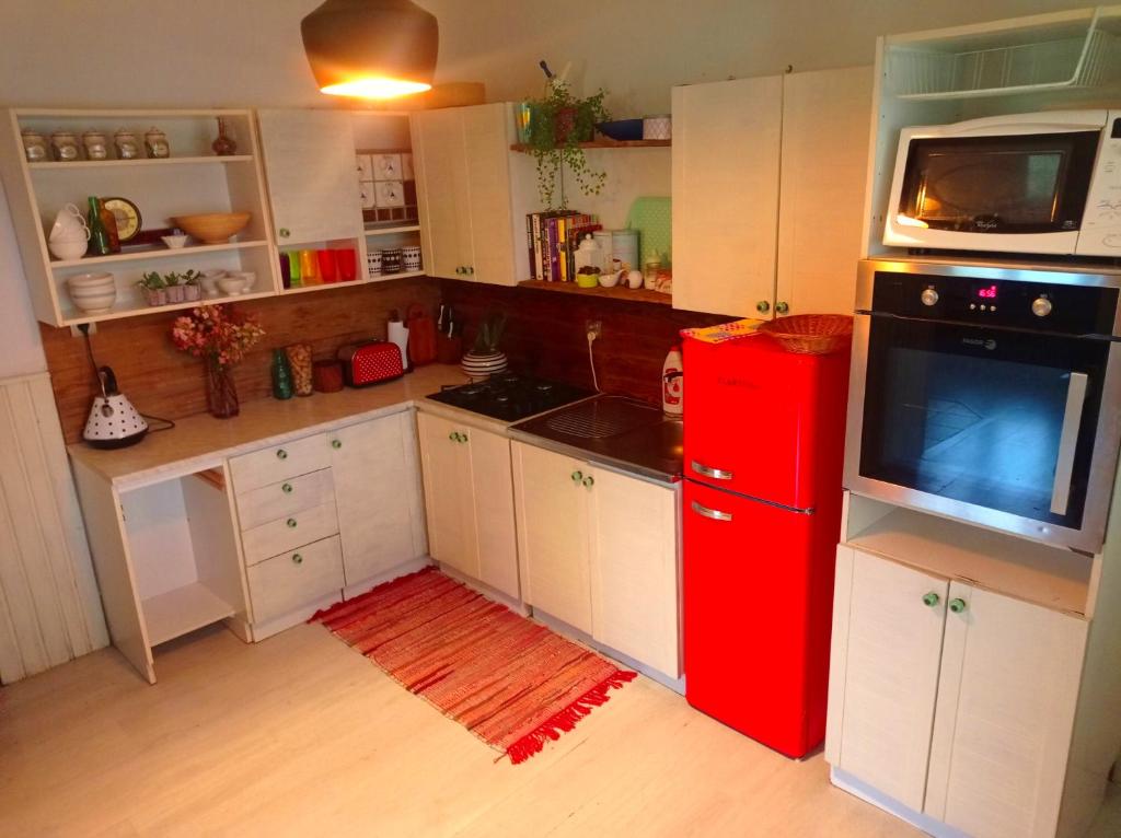 a kitchen with a red refrigerator and white cabinets at Apartmán Eva in Liptovský Svätý Peter