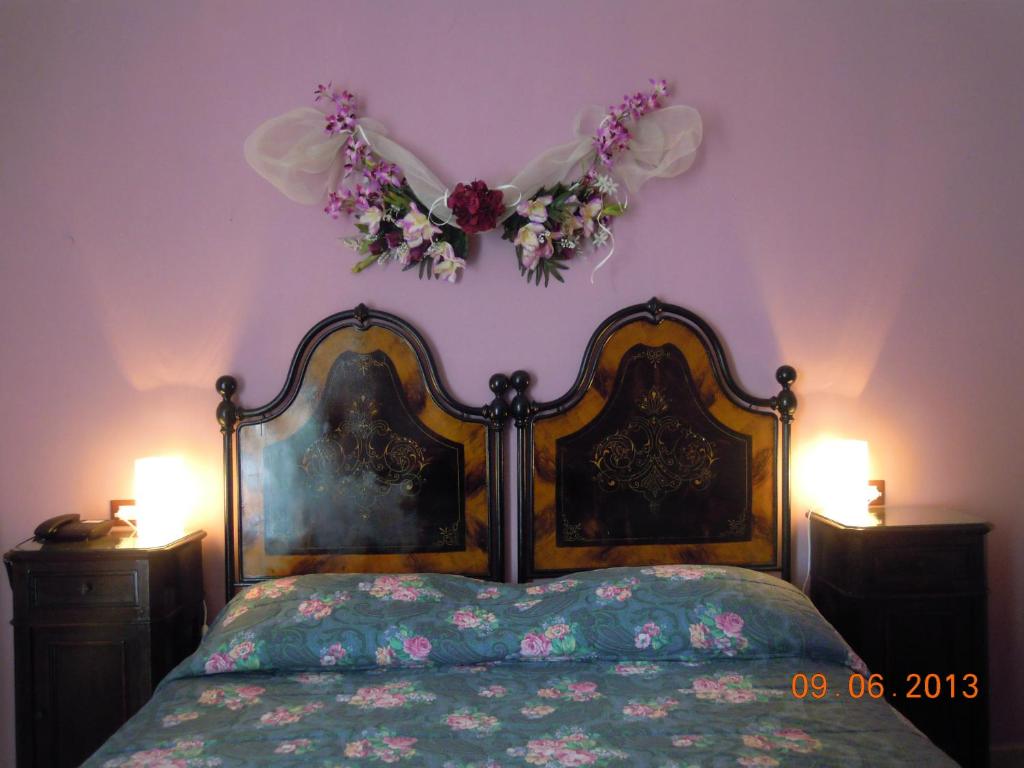 um quarto com uma cama com flores na parede em B&B Ciliegio Felice em Molinella