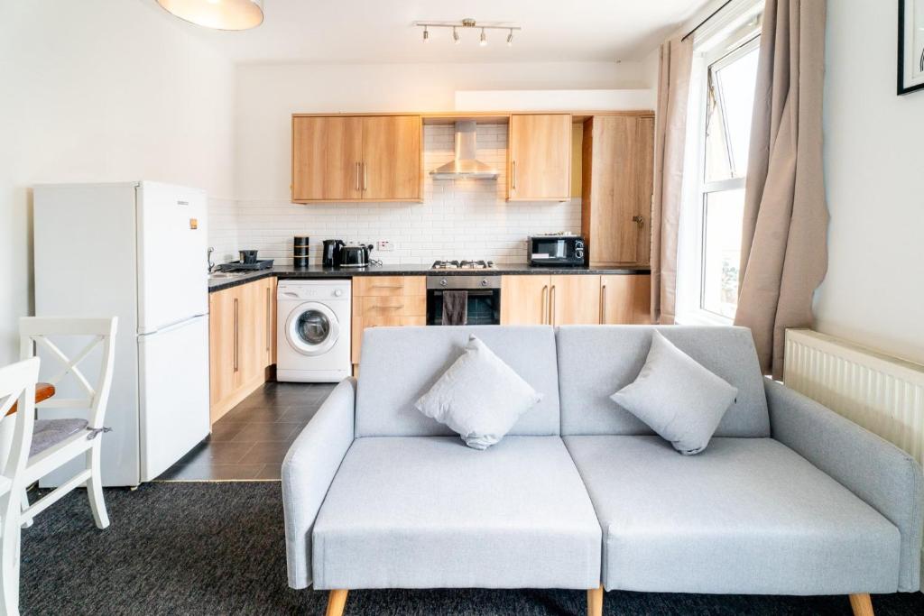 a living room with a couch and a kitchen at Cozy Urban - Retreat Modern 1BR - Free Parking in Bristol