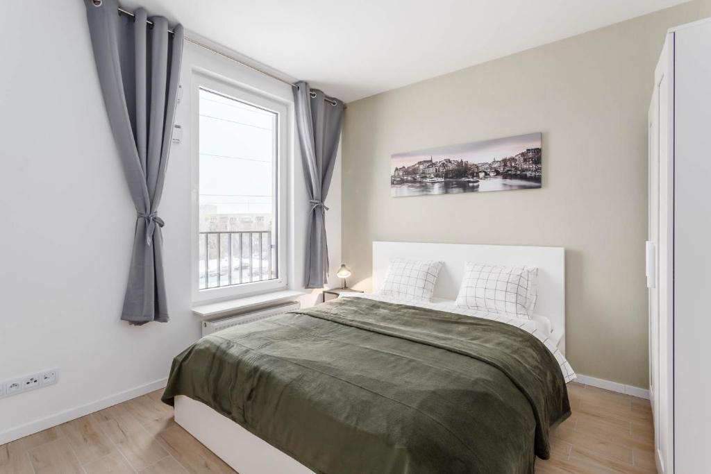 una camera da letto bianca con un letto e una finestra di Enjoy! Ursynów a Varsavia