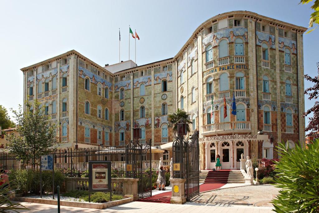 un gran edificio con una valla delante en Ausonia Hungaria Wellness & Lifestyle, en Lido de Venecia