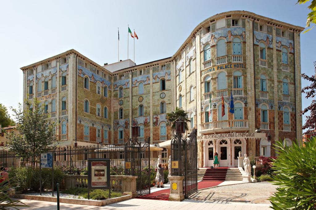 a large building with a clock on the front of it at Ausonia Hungaria Wellness & Lifestyle in Venice-Lido