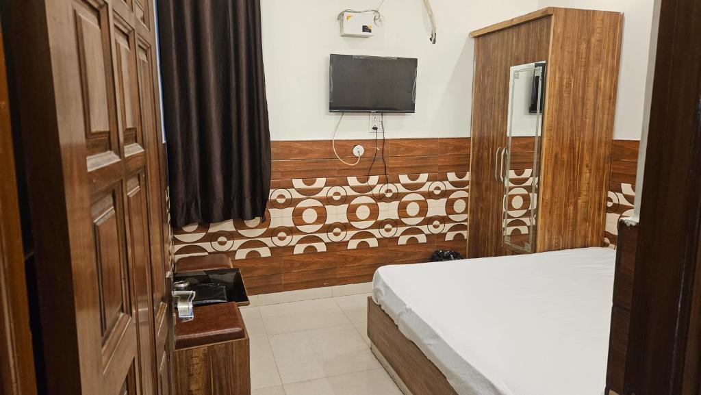 a bedroom with a bed and a tv on the wall at HOTEL COMFORT INN in Bhiwāni