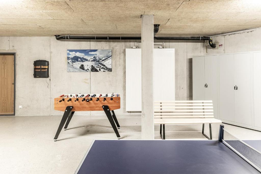 a ping pong table and a bench in a room at Sonnberg Aparts in Schröcken