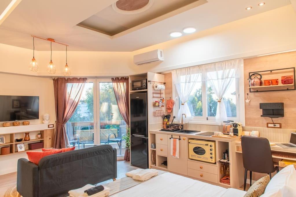 a living room with a couch and a kitchen at Central Kifissia ÁPPεROL Malomar Homing in Athens