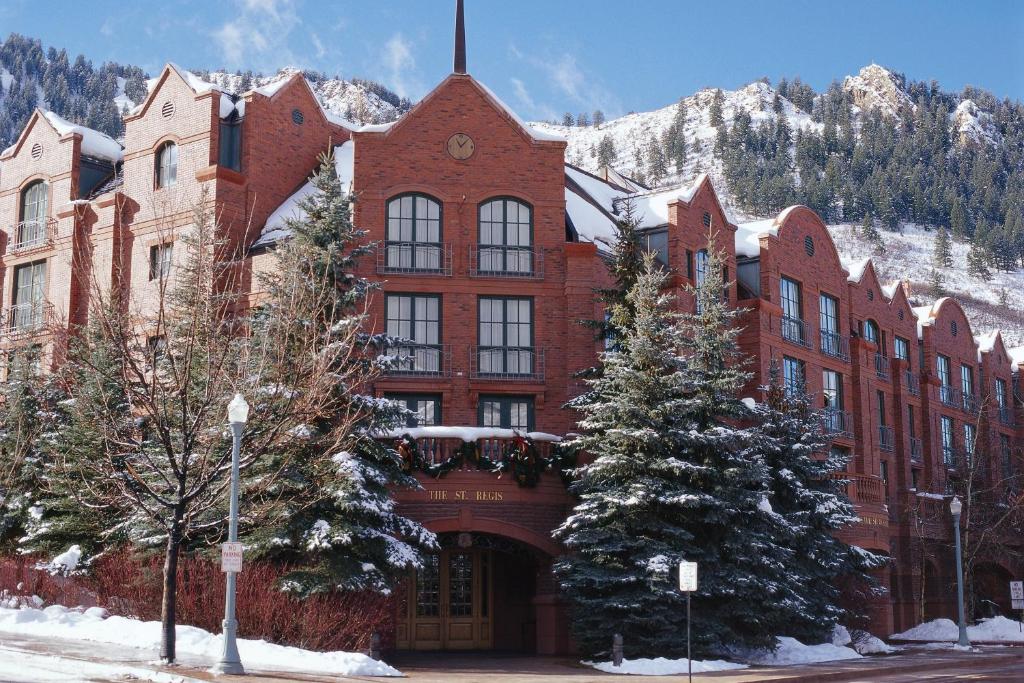 un gran edificio de ladrillo rojo con árboles delante de él en St. Regis Residence Club, Aspen, en Aspen