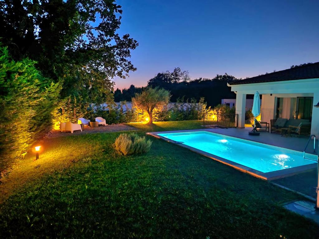 a backyard with a swimming pool at night at Villa Destiny Nedescina, Istrien, Kroatien in Nedeščina