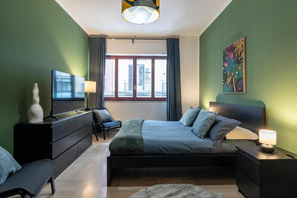 een slaapkamer met een bed, een bureau en een raam bij Home Principe Amedeo 184 in Bari