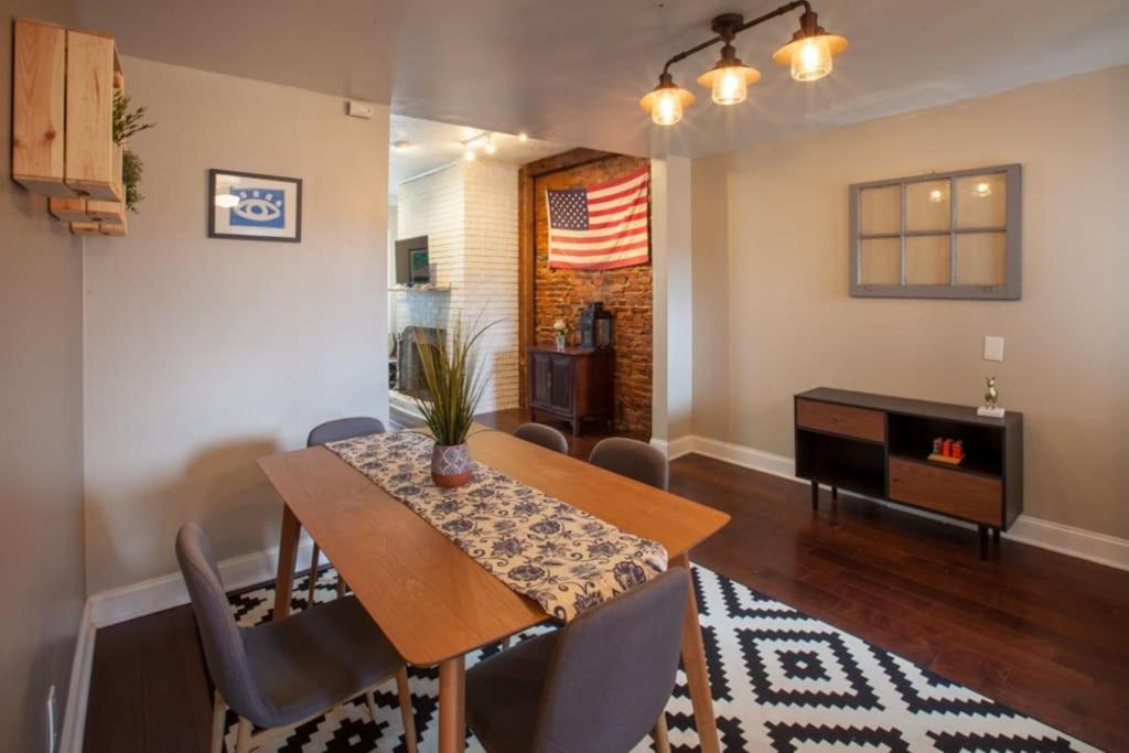 uma sala de jantar com uma mesa e cadeiras e uma bandeira americana em Great for Exploring * Stylish Loft Like Living em Pittsburgh