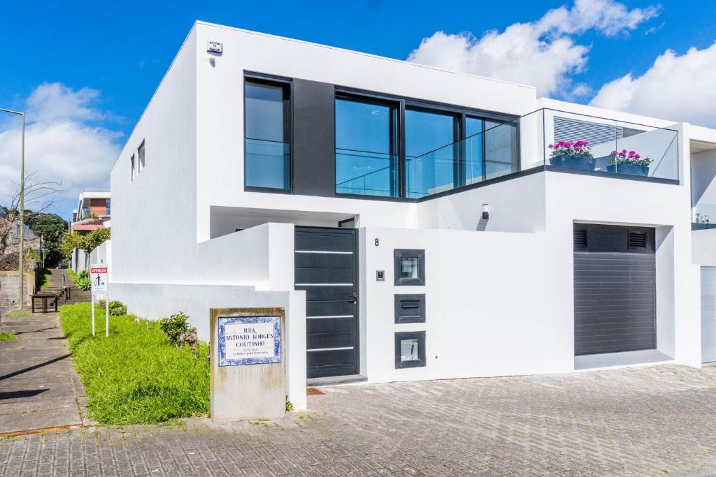 una casa bianca con porte e finestre nere di LUX House a Ponta Delgada