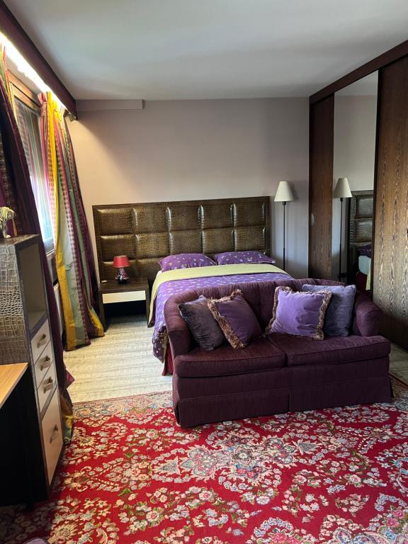 a bedroom with a bed and a purple couch at Studio dans le quartier luxe in Neuilly-sur-Seine