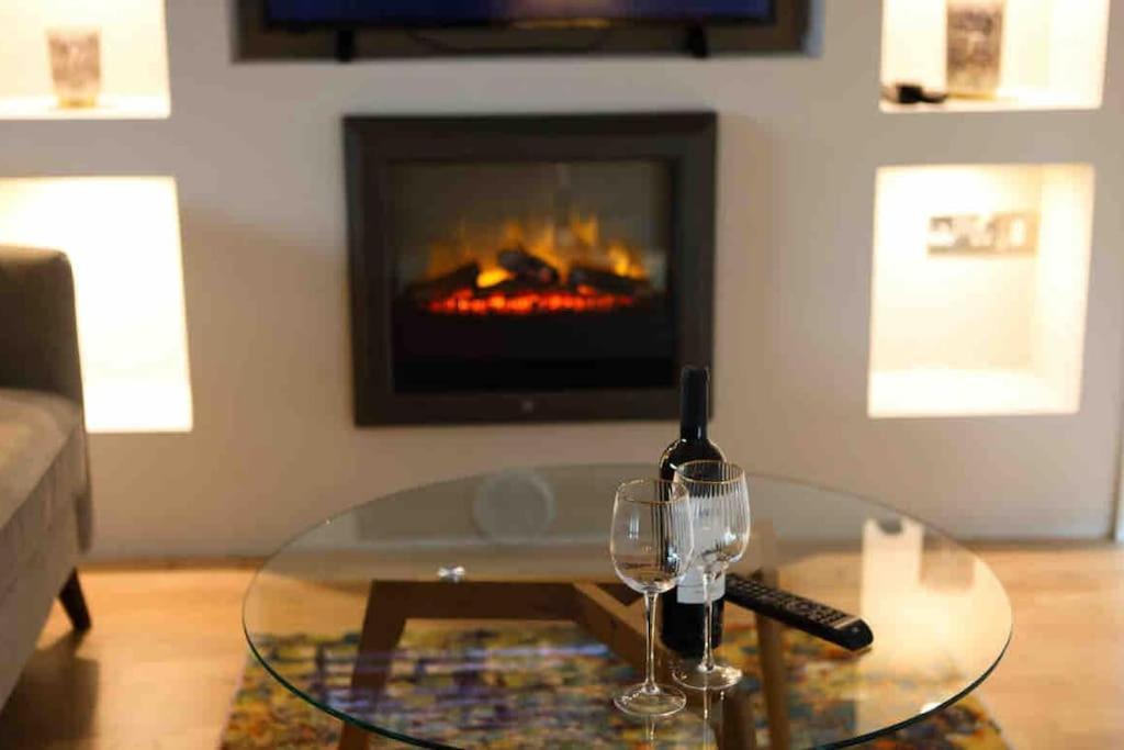 a glass table with two wine glasses and a fireplace at 5* Self Catering 1 Bed in Nenagh