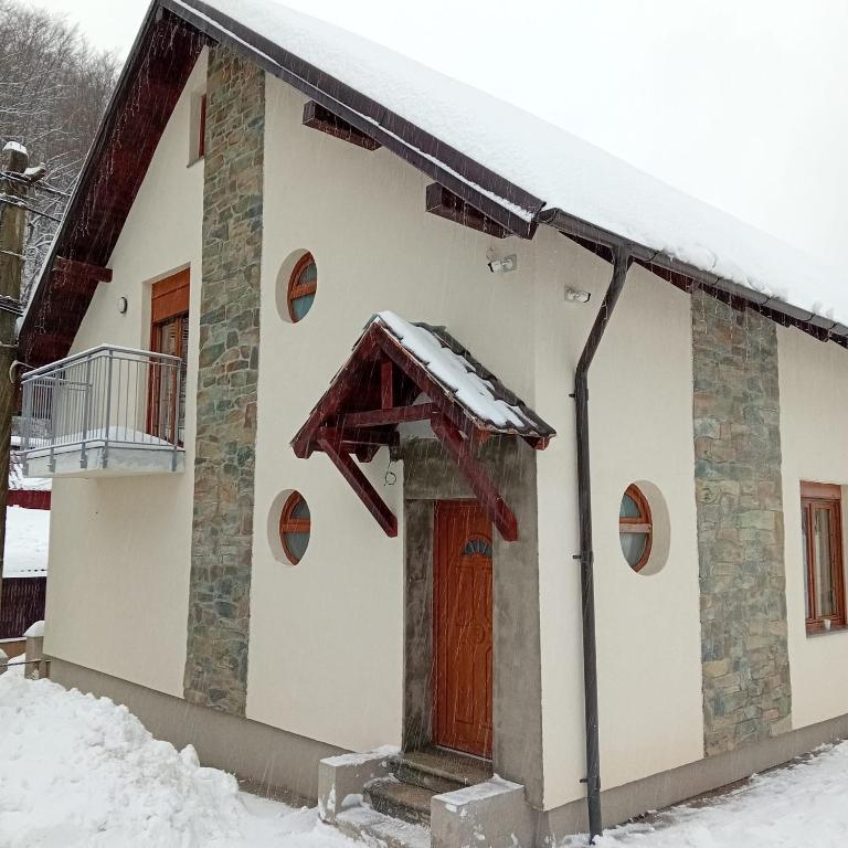 a house with snow on the roof at Casa Mont Blanc Cavnic apartament 2 in Cavnic