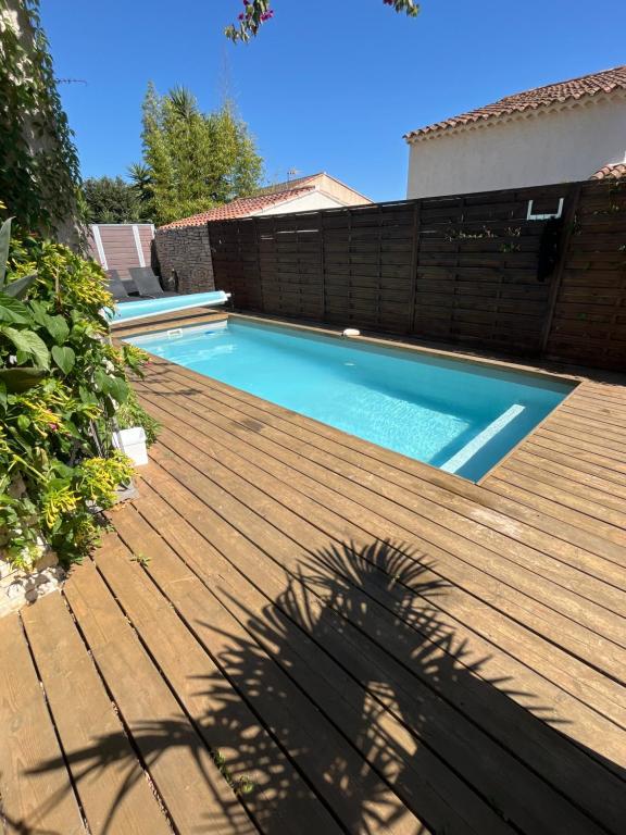 a swimming pool on top of a wooden deck at Superbe Villa entière contemporaine maison de vacances 120m2 super équipée de 2 à 10 couchages climatisation avec 3ch et 4 lits 140x190 -1 clic clac 120x190 et 1 salon avec canapé convertible 120x190 avec piscine,pétanque, cuisine et barbecue in Six-Fours-les-Plages