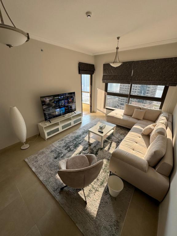 a living room with a couch and a tv at Sharja 1302 in Sharjah
