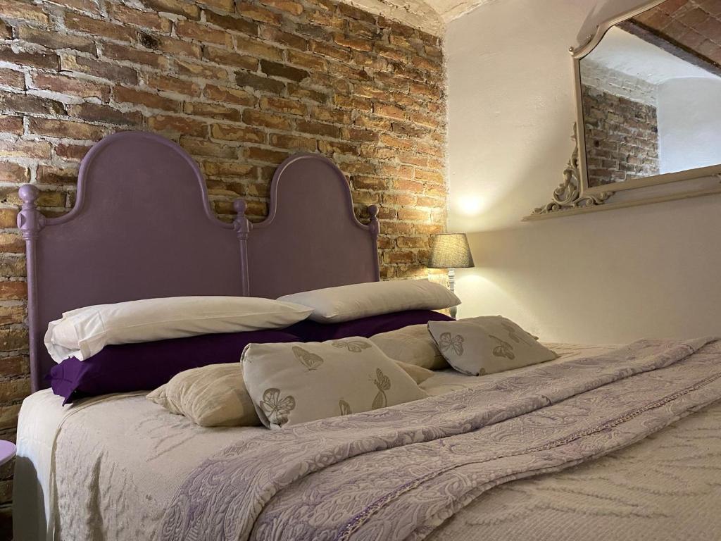 1 dormitorio con 1 cama grande y pared de ladrillo en La Culla di Bacco, en Castagnole Monferrato