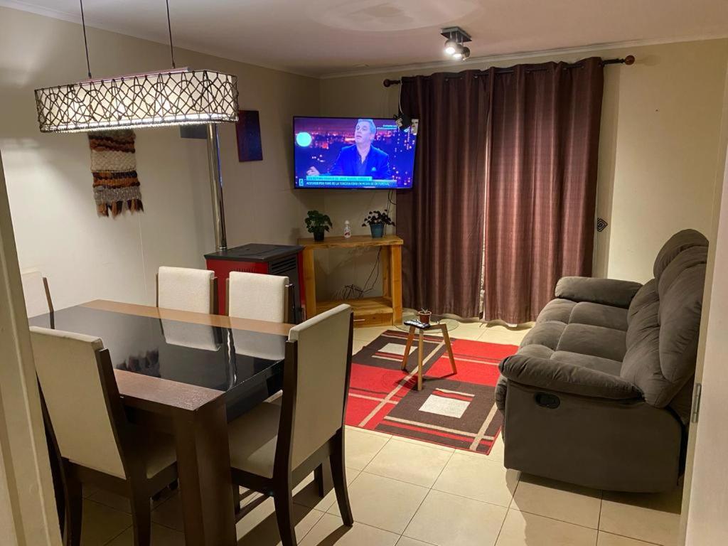 a living room with a dining table and a television at Arriendo casa por día in Villarrica