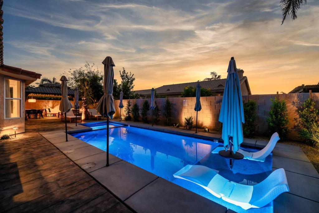 インディオにあるThe Crescendo Stylish Modern Pool Homeの裏庭のパラソル付きスイミングプール