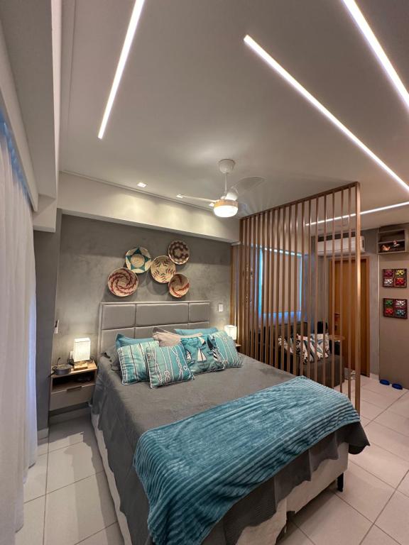 a bedroom with a large bed with blue sheets at Muro Alto Makia flat cinematográfico in Porto De Galinhas
