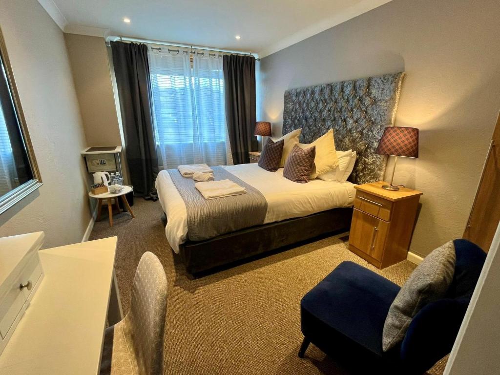 a hotel room with a bed and a chair at Bishops Park At Fingle Glen Golf Hotel in Exeter