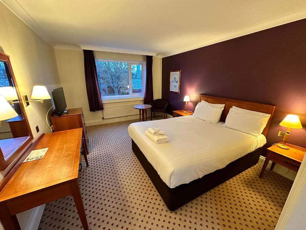 a hotel room with a bed and a window at Sporting Lodge Inn Middlesbrough in Middlesbrough