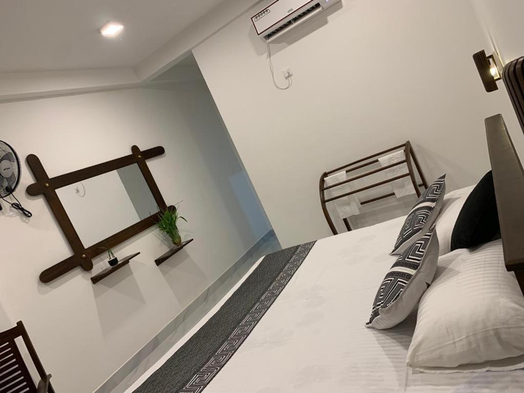 a bedroom with a bed with a clock on the wall at IBEEZA MOTEL in Babarenda Central