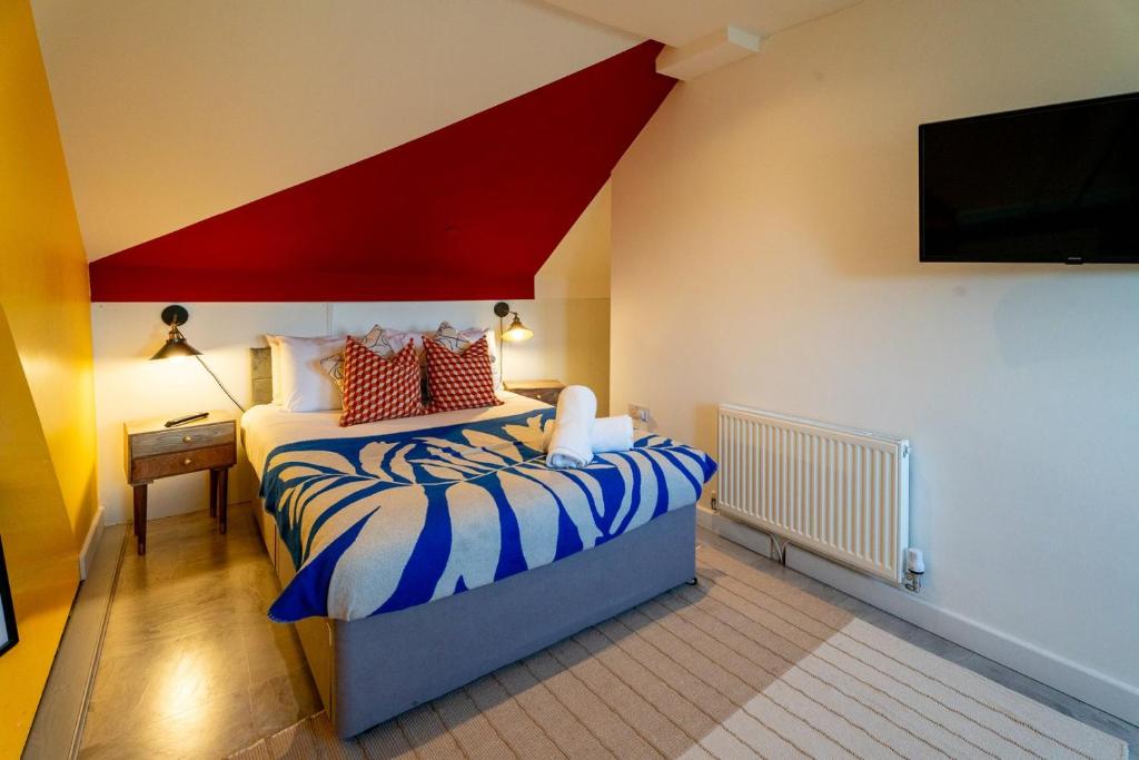 een slaapkamer met een bed met een rood en wit plafond bij Cardiff Getaway - City Center - Free Parking in Cardiff