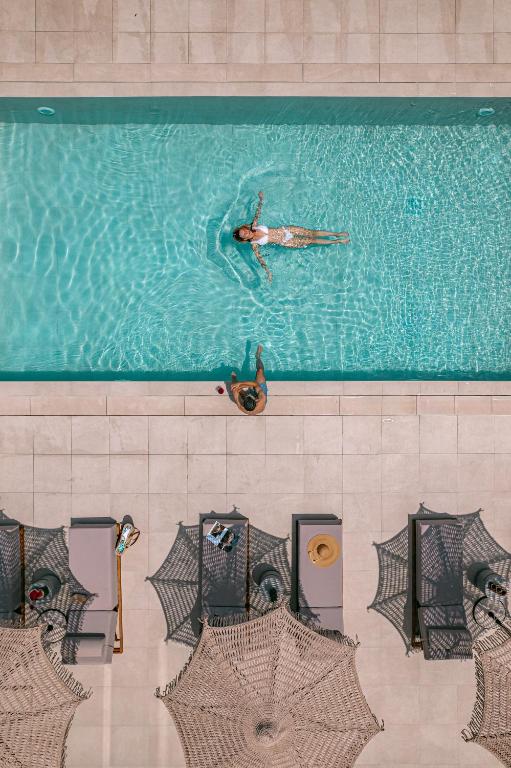 a person swimming in a swimming pool at OPSIS Suites in Limenaria