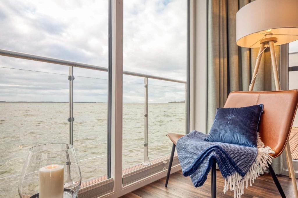 a room with a chair and a window looking out at the ocean at Hausboot Große Freiheit in Ribnitz-Damgarten