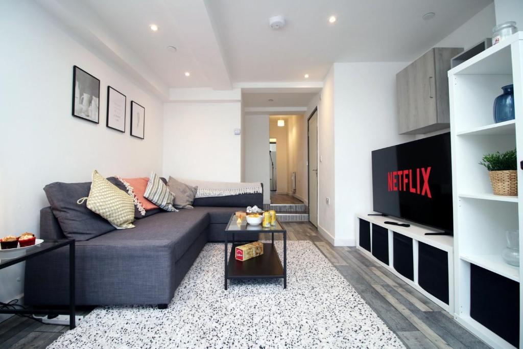 a living room with a couch and a tv at Cardiff Getaway | City Center | Free Parking in Cardiff