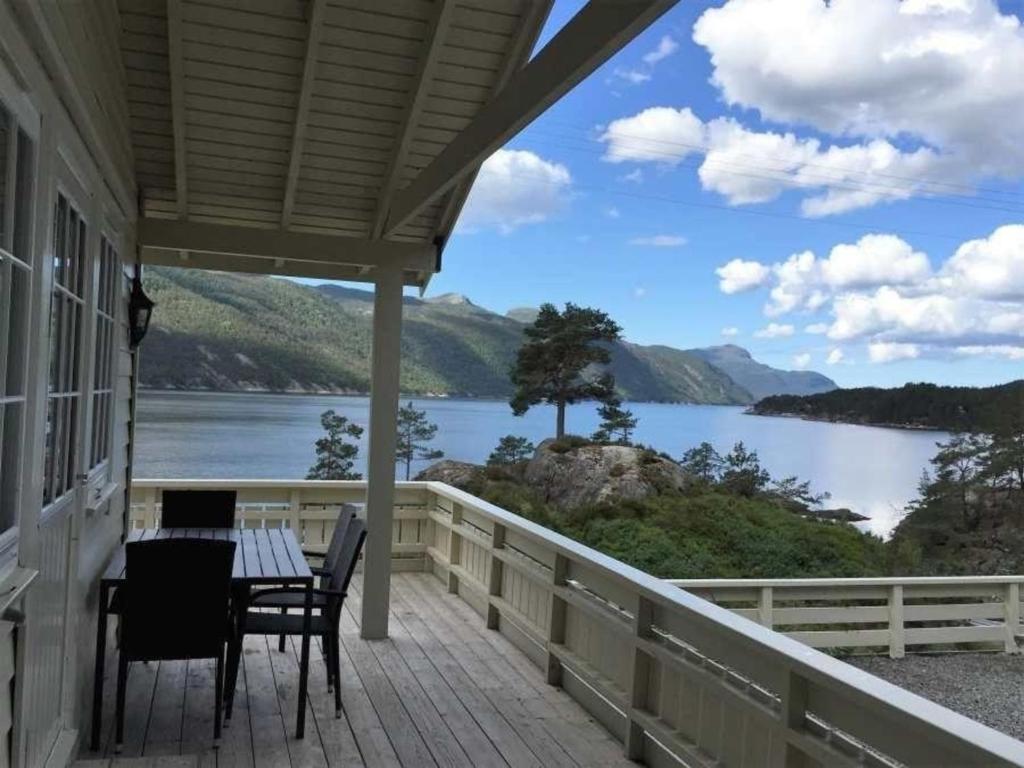 une terrasse couverte avec une table et des chaises et une vue sur le lac. dans l'établissement Ferienhaus in Sand mit Offenerem Kamin, à Sand