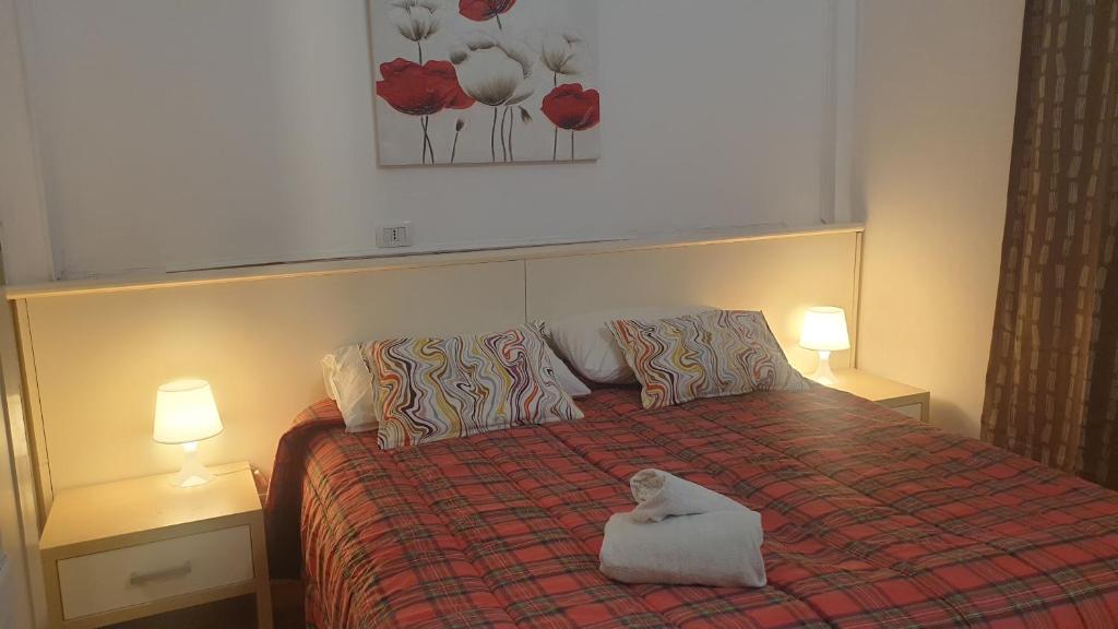 een slaapkamer met een bed met een witte handdoek erop bij Home Hostel Catania in Catania