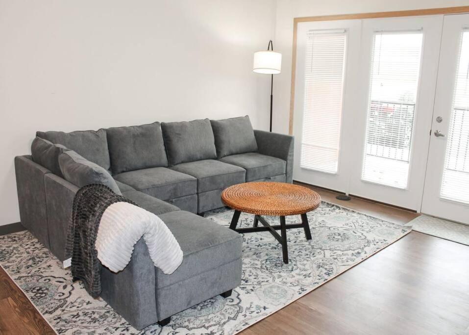 a living room with a gray couch and a table at Main Street Sun Prairie WI - 2 Bedroom in Sun Prairie