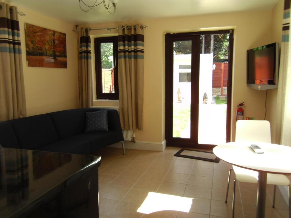 a living room with a couch and a table at Aberdeen Guest House in Ilford