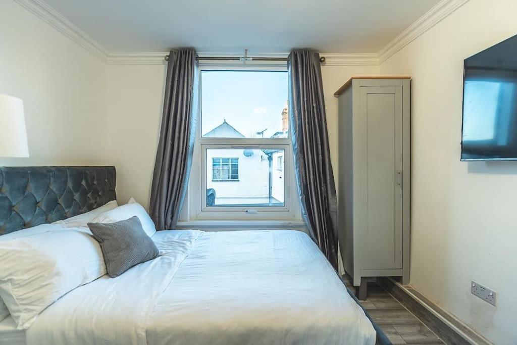 ein Schlafzimmer mit einem Bett und einem großen Fenster in der Unterkunft Cozy studio for your stay in New Southgate