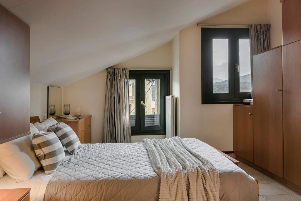 - une chambre avec un grand lit et 2 fenêtres dans l'établissement Koutouki home!, à Argostóli