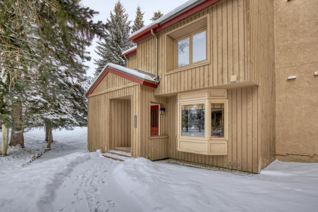 una casa in legno con una porta rossa nella neve di Stunning Summit Condo with Sauna, Hot Tub, Pickleball a Sun Valley