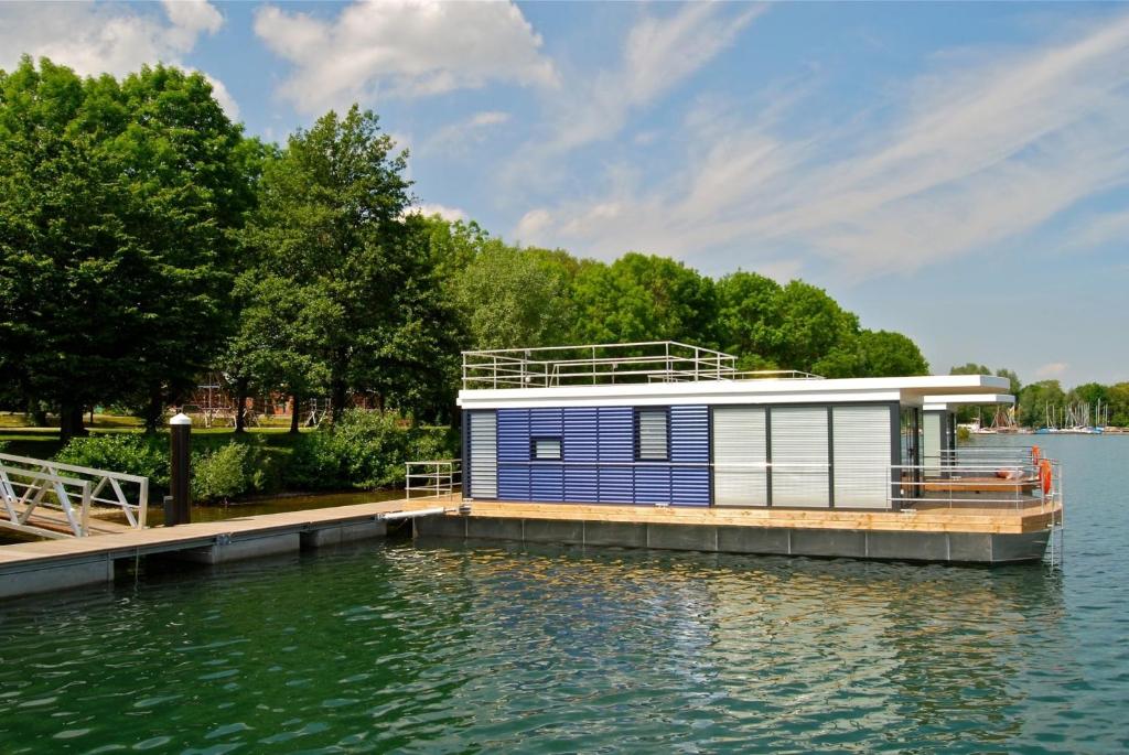 a house on a dock on a body of water at Hausboot Hering - LP7 in Höxter