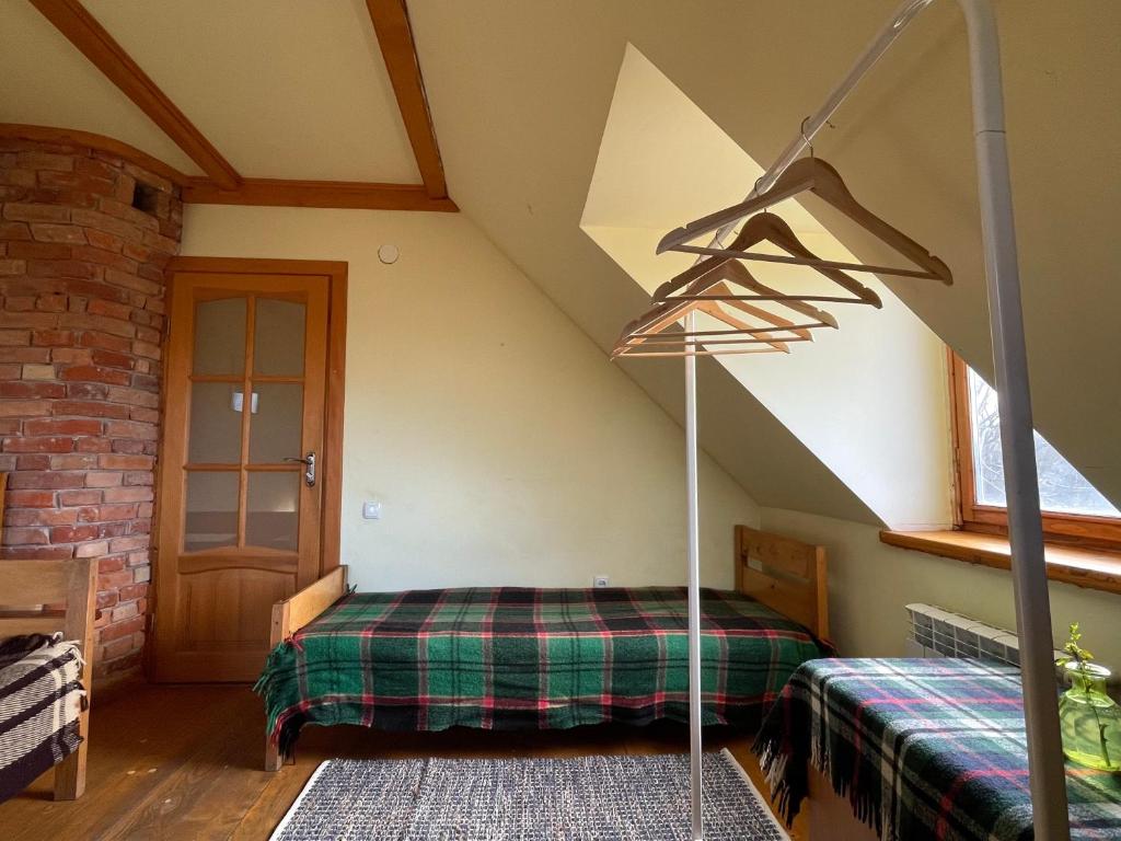 1 dormitorio con 1 cama en el ático en Tisnyi 7 Guest House, en Kamianets-Podilskyi